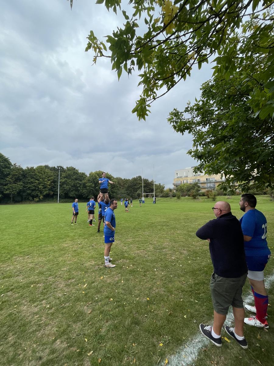 Échauffement des alumni en touche, sous le regard de supporters